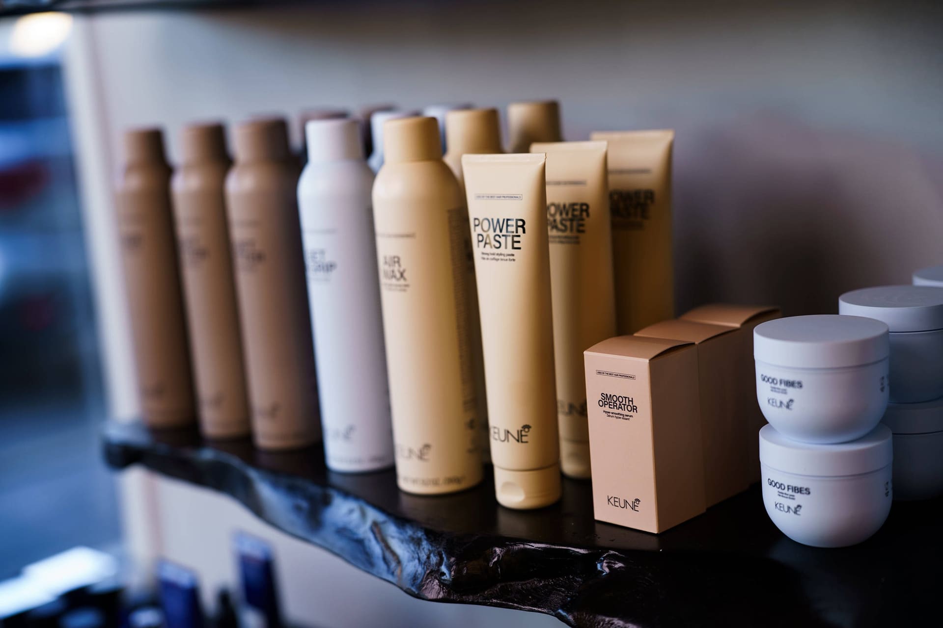 Keune tubes and jars on a black live-edge shelf